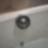 Close-up of a bathtub drain showing signs of blockage