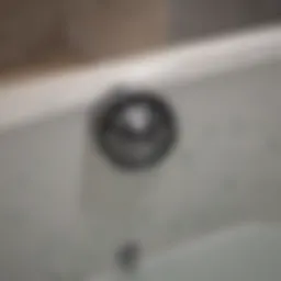 Close-up of a bathtub drain showing signs of blockage